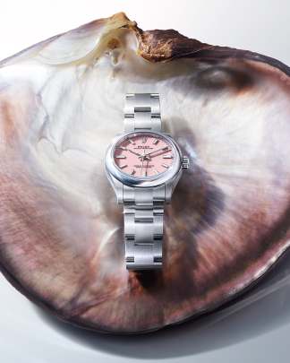 Rolex Oyster Perpetual watch featuring a pink dial and an Oyster bracelet.  Rolex